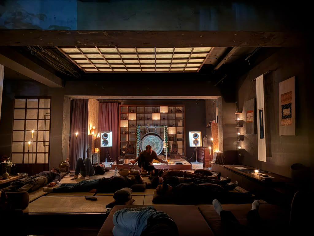 A sound bath in progress beneath the paper-lantern ceiling